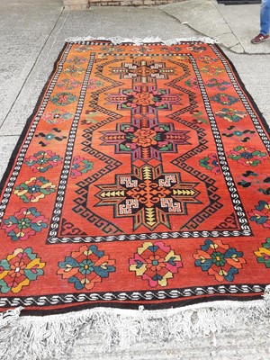 Lot 1093 - Eastern wool rug, second half 20th century, with geometric panels on orange ground