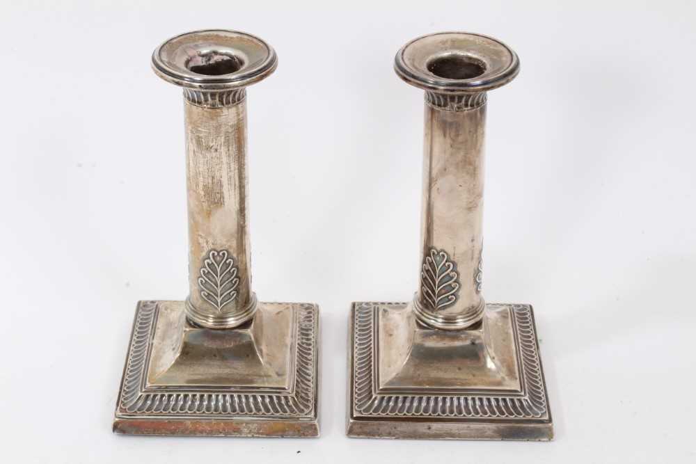 Lot 255 - Pair 1920s silver candlesticks, with plain columns and leaf decoration, on square bases