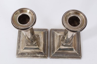 Lot 255 - Pair 1920s silver candlesticks, with plain columns and leaf decoration, on square bases