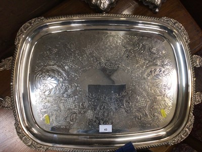 Lot 43 - Silver plated two handled tray it's engraved foliate decoration and gadrooned borders, together with a pair of decorative plated candlesticks