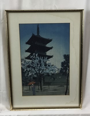 Lot 18 - Japanese woodblock print in frame, depicting a female figure holding a parasol with a pagoda in the background, possibly after Shiro Kasamatsu