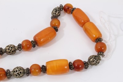 Lot 38 - Amber bead necklace with white metal spacers and tassel terminal