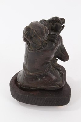 Lot 703 - Chinese bronze figure of a man making a devotional offering, on a later wooden base