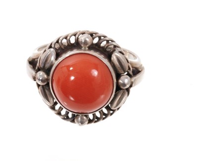 Lot 1977 - Georg Jensen silver and coral ‘moonlight blossom’ dress ring with a round coral cabochon in silver setting with scrolls and foliage, model 1 C, signed. Finger size approximately O1/2-P.