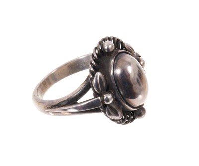 Lot 1978 - Georg Jensen silver ‘moonlight blossom’ dress ring with an cabochon silver centre in silver setting with scrolls and foliage, model 1 A, signed. Finger size approximately M.