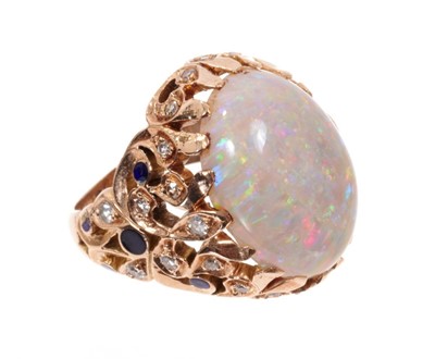 Lot 1980 - Opal, diamond and enamel cocktail ring with a large oval cabochon opal measuring approximately 19mm x 14mm in pierced gold foliate setting with single cut diamonds and black enamel decoration. Fing...