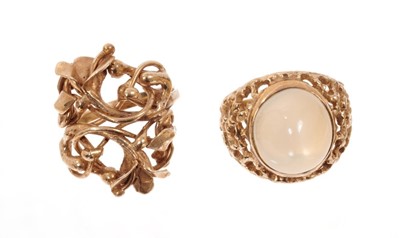 Lot 1983 - Two gold dress rings, one with a cabochon stone, the other with openwork woven floral design. Finger size approximately L-M.