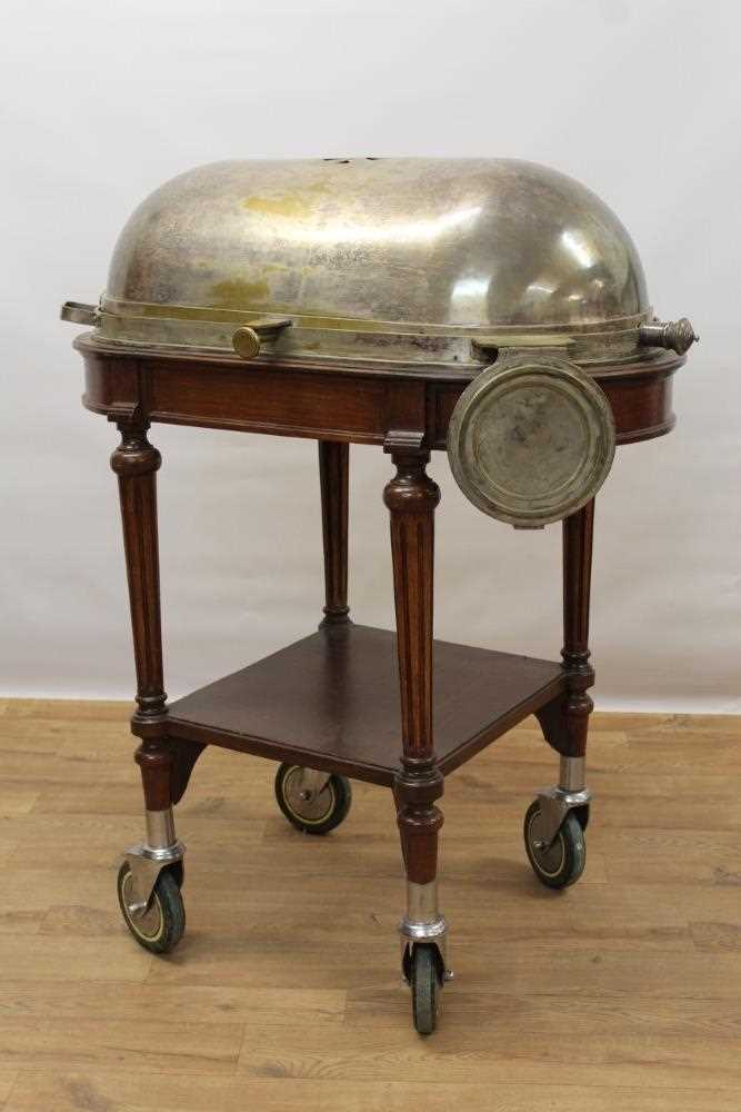 Lot 1478 - Impressive early 20th century mahogany serving trolley, with silver plated domed cylinder cover and folding dish stand, raised on fluted legs with tier below on substantial castors, 98cm wide