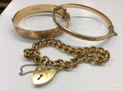 Lot 667 - Two gold plated bangles and gold plated padlock bracelet