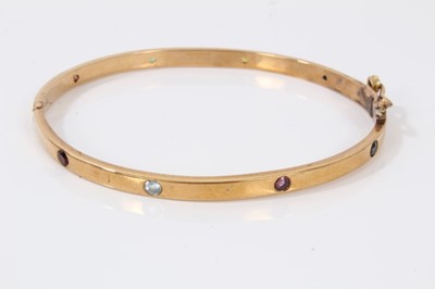 Lot 36 - 9ct gold hinged bangle set with eight multi coloured sapphires
