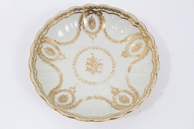 Lot 20 - Worcester fluted tea bowl and saucer, circa 1775-80, decorated in gilt with swags and other patterns, the saucer measuring 14cm diameter