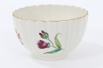 Lot 24 - Worcester fluted tea bowl and saucer, circa 1772, polychrome painted with flowers, with gilt rims, the saucer measuring 13.5cm diameter