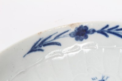 Lot 55 - Worcester blue and white strap-fluted saucer dish, circa 1756, decorated with scrollwork panels containing Chinese landscapes, and foliate patterned rim, 18.5cm diameter