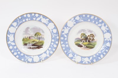 Lot 56 - Pair of New Hall plates, circa 1815-20, with printed and coloured titled scenes, the edges with relief moulded foliate patterns on a blue ground, 20.5cm diameter