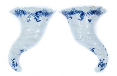 Lot 247 - Rare pair of Worcester cornucopia wall pockets, circa 1755, moulded with landscape scenes, with floral and other patterns in underglaze blue, painter's marks to backs, 21cm long