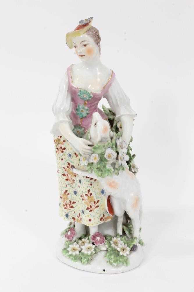 Lot 66 - Derby figure of a shepherdess, circa 1760-65, polychrome and gilt decorated, shown garlanding a lamb, standing on a floral encrusted base, patch marks to base, 19.5cm high
