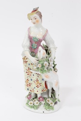 Lot 66 - Derby figure of a shepherdess, circa 1760-65, polychrome and gilt decorated, shown garlanding a lamb, standing on a floral encrusted base, patch marks to base, 19.5cm high