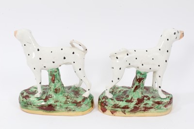 Lot 68 - Pair of Staffordshire pottery models of Dalmatians, shown standing on naturalistic bases, 16cm high