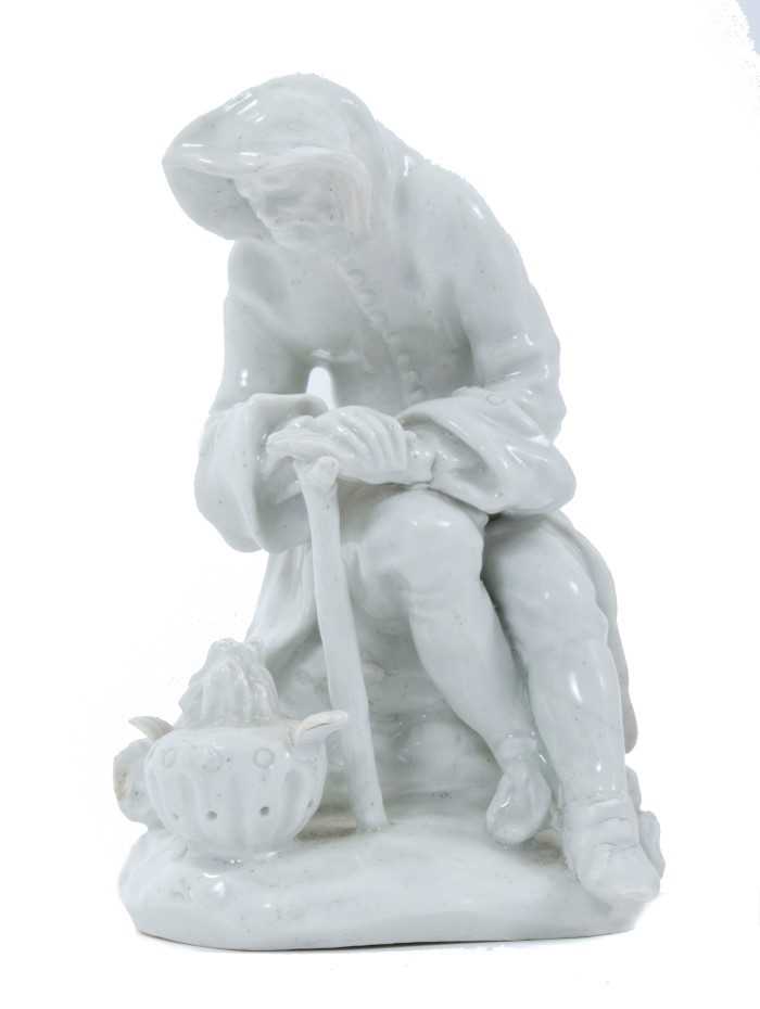 Lot 73 - Bow blanc de chine figure, circa 1755, in the form of a seated elderly man warming his hands on a brazier, emblematic of Winter, 12.5cm high