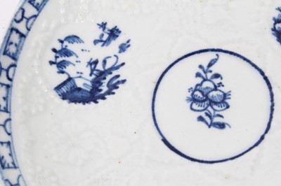 Lot 80 - Lowestoft blue and white saucer, circa 1765, relief moulded, with circular panels containing Chinese landscapes and a patterned border, 12.25cm diameter