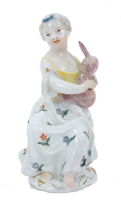 Lot 318 - Meissen figure of a young girl, circa 1755, shown seated on a tree stump playing pipes, decorated in enamels and gilt, incised number 23 to base, 12cm high