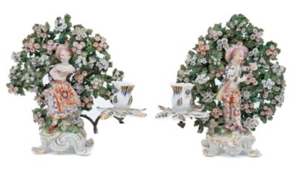 Lot 84 - Pair of Bow 'New Dancer' figure candlesticks, circa 1765, with bocage decoration behind each figure, standing on scrollwork bases, 24cm high