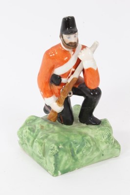 Lot 85 - Unusual Derby (King Street Works) figure of a kneeling soldier, circa 1890-1910, polychrome enamelled on a square naturalistic base, marks underneath, 10cm high