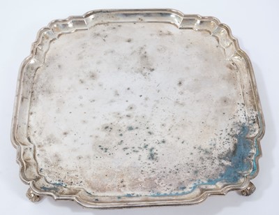 Lot 332 - George V silver salver of shaped square form with piecrust border, on four leaf scroll feet
