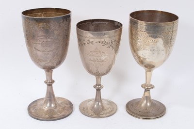 Lot 338 - Three silver trophy cups of conventional form, with engraved floral decoration and inscriptions