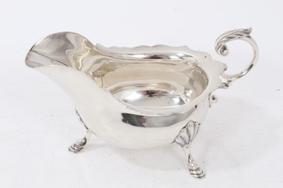 Lot 355 - 1940s silver sauce boat of conventional form, with wavy border and leaf mounted, open scroll handle