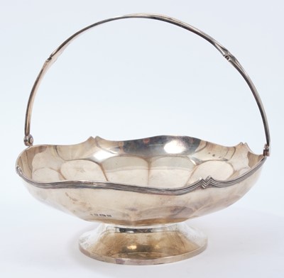 Lot 357 - !920s silver cake basket of circular form, with faceted panels and reeded swing handle