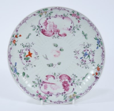 Lot 223 - Worcester pleat-moulded saucer dish, circa 1756-58, painted in the Meissen style with puce landscapes in scrollwork panels, flowers and foliate patterns, 18.5cm diameter