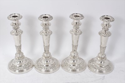 Lot 371 - A set of four Old Sheffield plate candlesticks with scroll, shell and floral borders