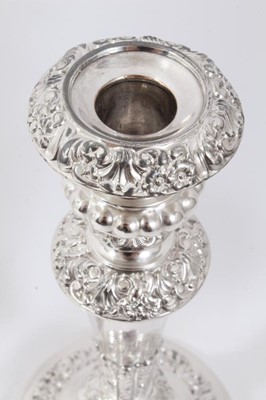 Lot 371 - A set of four Old Sheffield plate candlesticks with scroll, shell and floral borders