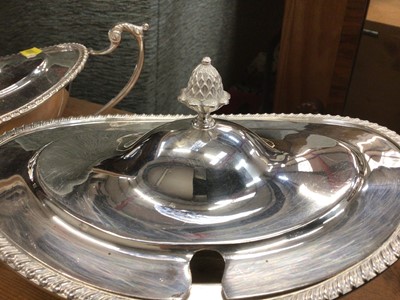Lot 49 - A pair of silver plate sauce tureens in the Adam style of oval form on a raised foor with gadroon border, swan handles and pineapple finial