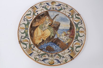Lot 108 - Good pair of Italian maiolica dishes, probably early 20th century, decorated with classical scenes, the borders with a pattern of cherubs, masks and scrollwork motifs, 40cm diameter