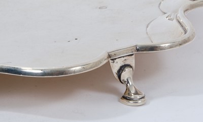 Lot 379 - Early George V silver salver of shaped square form, with piecrust border, on four hoof feet