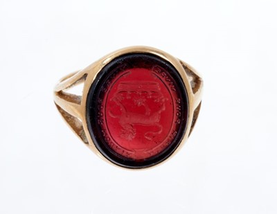 Lot 563 - Victorian gold signet ring, the oval garnet/red coloured glass bezel with intaglio engraved family crest depicting a lion above a coronet and Latin motto. Ring size approximately J½.