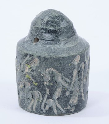 Lot 802 - Rare early carved stone cylinder seal, possibly Assyrian, with pierced terminal and profusely carved with figures ans animals, similarly carved to the foot, 6cm high