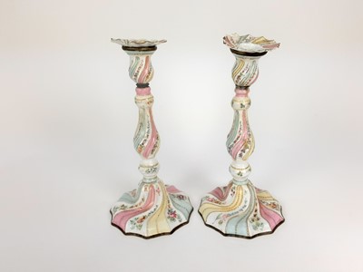 Lot 1937 - Pair of 18th century enamelled candlesticks, possibly Bilston, with spiralling knopped stems, painted with panels of flowers, 26.5cm high (a/f)