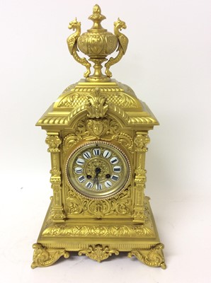 Lot 662 - Impressive late 19th century gilt metal mantel clock with cast urn mount, human mask and floral scroll decoration, French movement striking on bell , 49 cm high, key and pendulum present