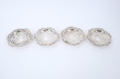Lot 424 - Set of four 1930s silver dishes of circular form, with raised scroll and floral borders