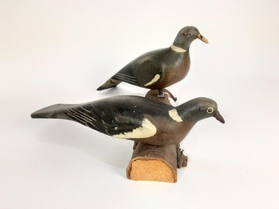Lot 991 - Two painted wooden decoy pigeons mounted on a log
