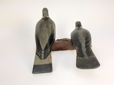 Lot 991 - Two painted wooden decoy pigeons mounted on a log