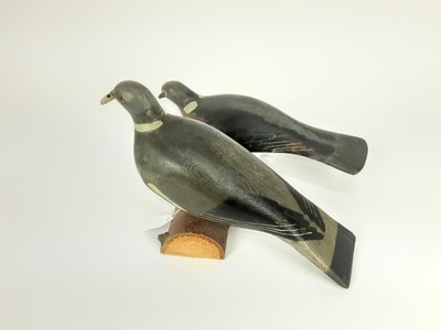Lot 991 - Two painted wooden decoy pigeons mounted on a log