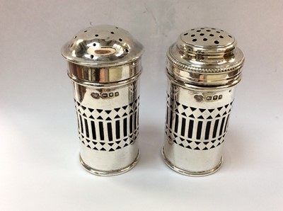 Lot 720 - Pair of silver pepper and salts with pierced decoration and blue glass liners