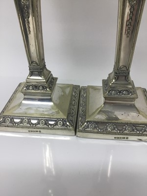 Lot 84 - Pair of late Victorian silver plated candlesticks with neoclassical decoration by Hawksworh Eyre & Co.