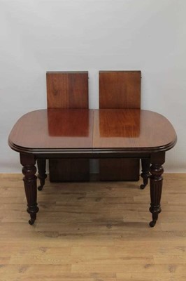 Lot 995 - Late 19th/early 20th century mahogany extending dining table by Selbat, of rounded rectangular form, with wind out mechanism, raised on turned fluted supports and castors, together with two additio...