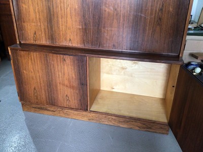 Lot 1002 - Mid century Danish rosewood two height bookcase with open shelves, fall flap enclosing stationary compartment above and two panelled cupboard doors below