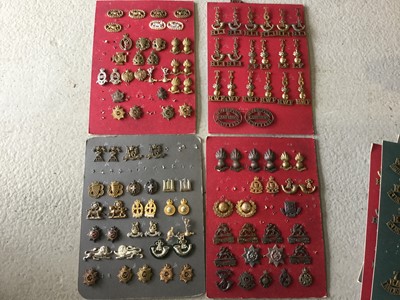 Lot 806 - Four boards each mounted with British military cap badges and shoulder titles